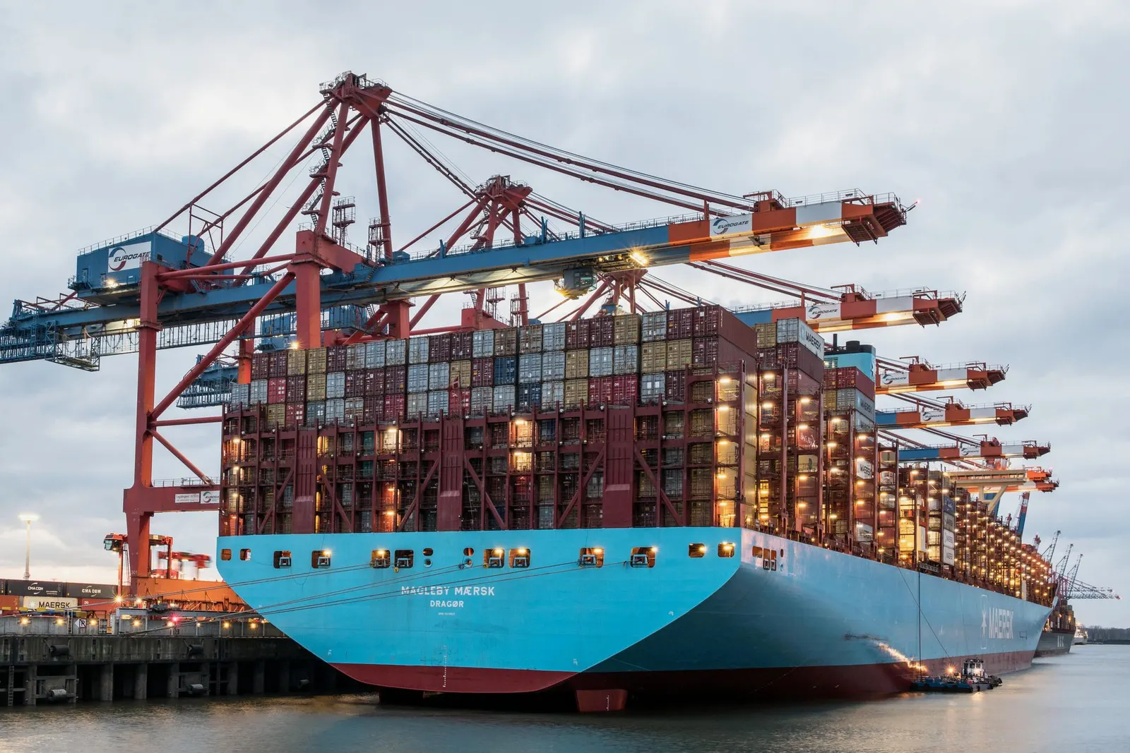 Gantry cranes loading shipping containers onto a container ship at a port