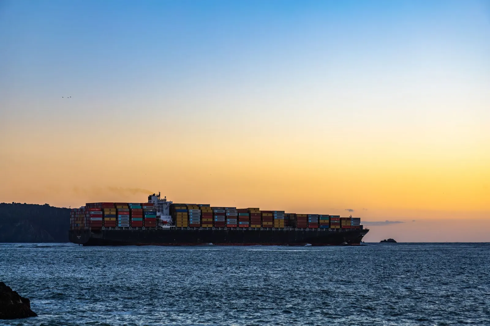 Container ship at sea at sunset