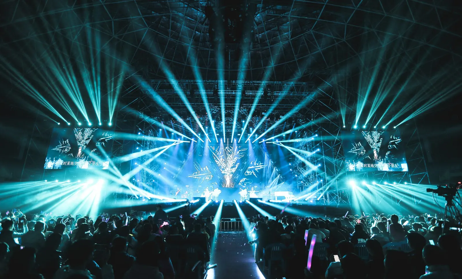 Stage lights and audience at a large live event
