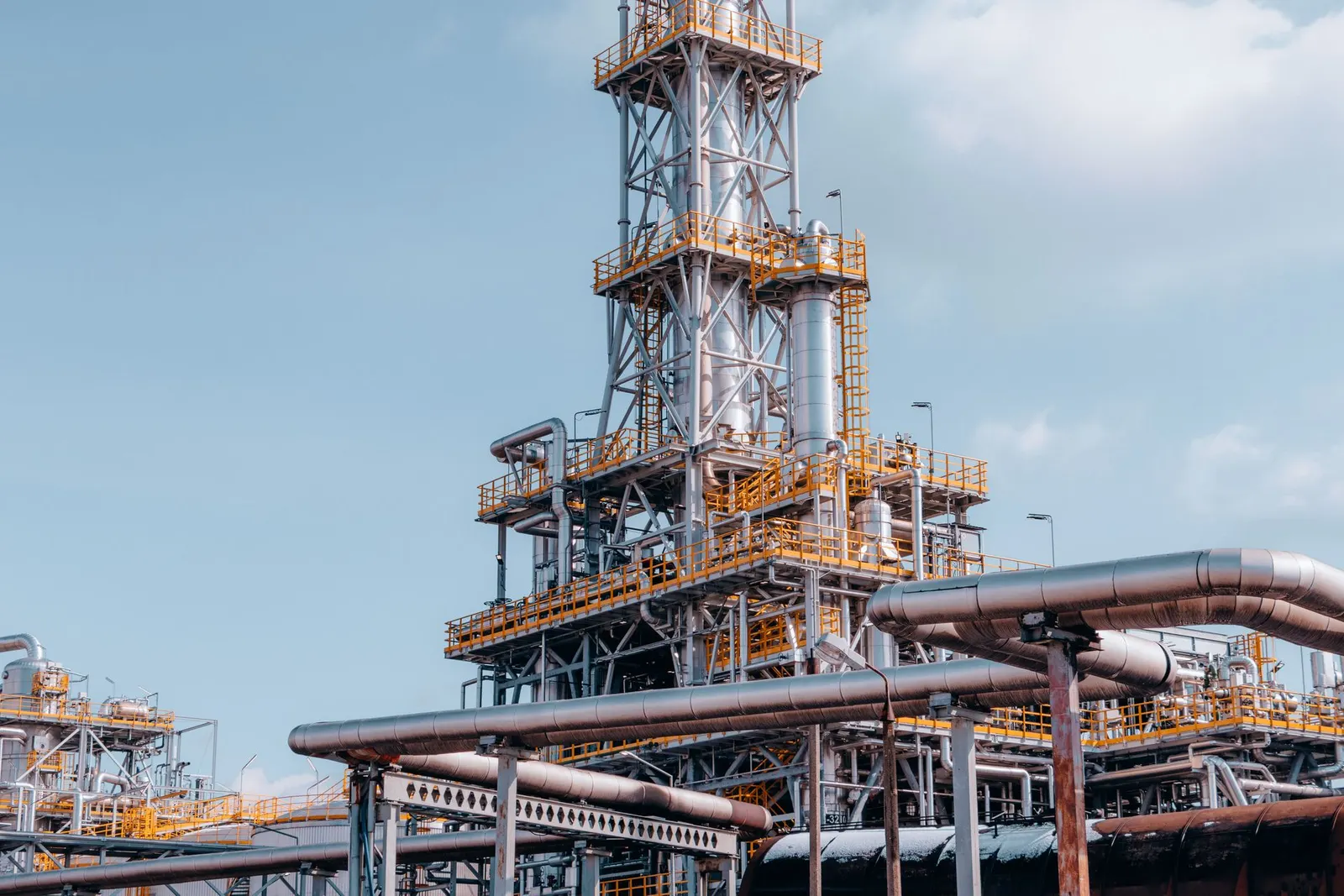 Oil refinery tower and pipework against the sky