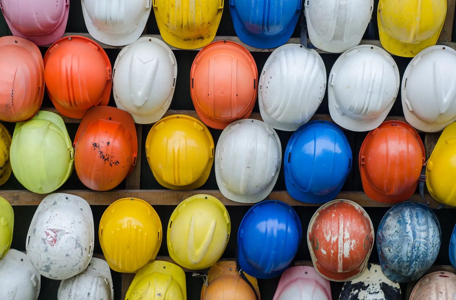 Rows of colourful construction safety helmets