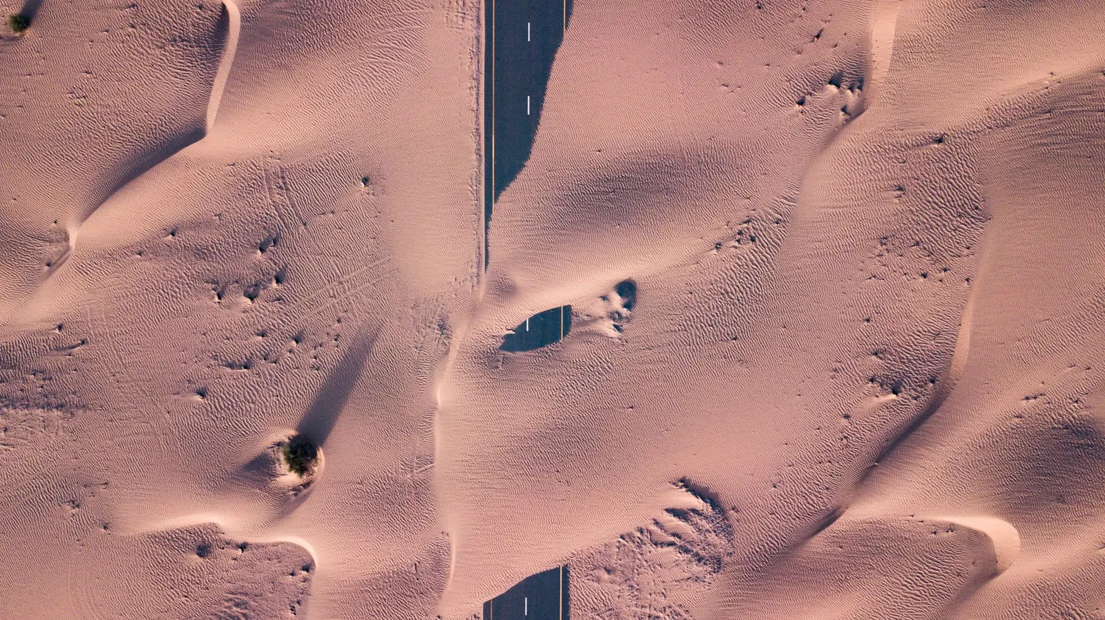 Aerial view of a highway crossing desert sand dunes in Saudi Arabia