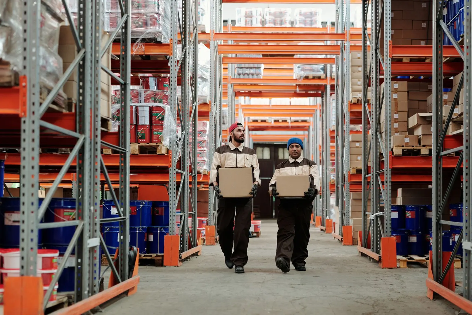 Warehouse staff carrying parcels between racking