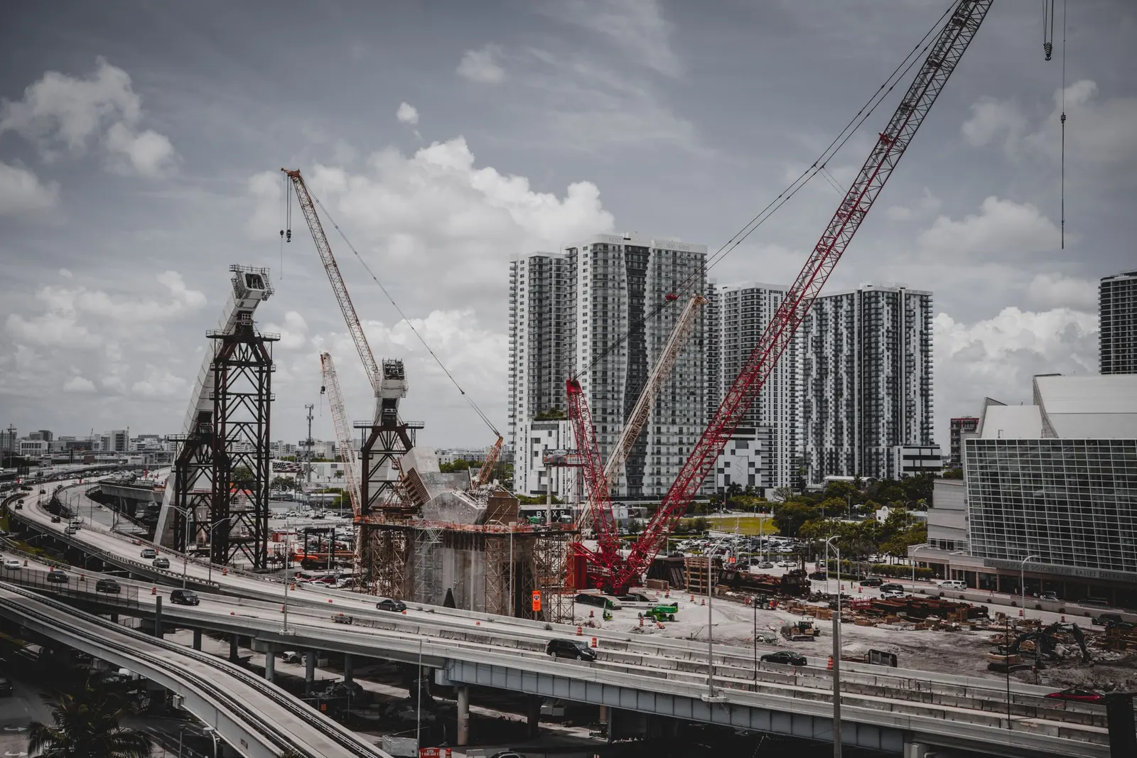 Construction site with tower cranes beside high-rise buildings
